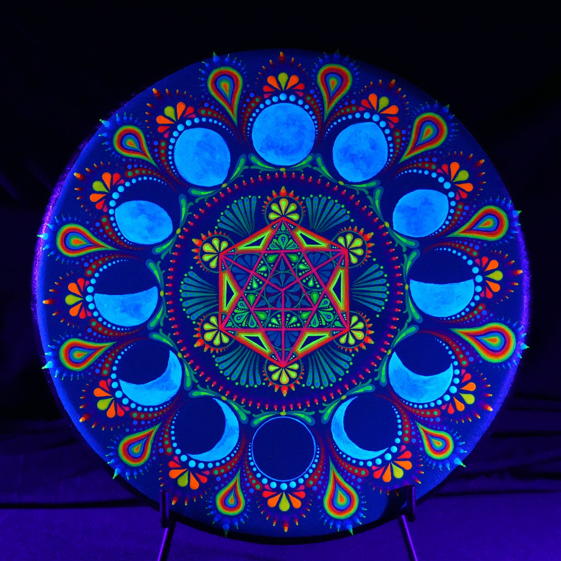 Colorful mandala design under black light on a dark background