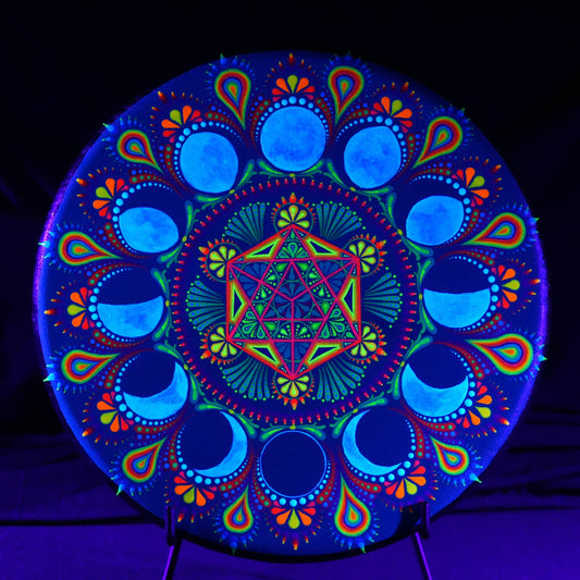 Colorful mandala design under black light on a dark background